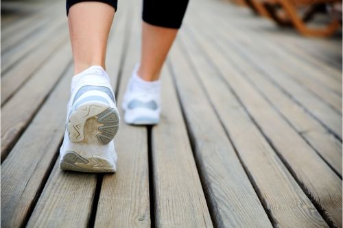 A woman's feet walking in trainers